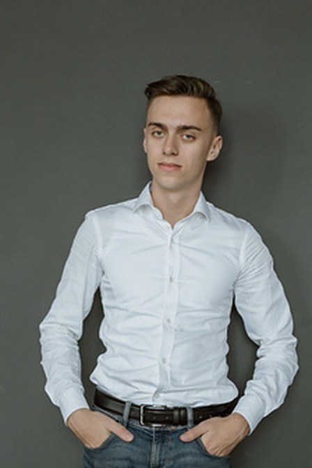 Mihai Corețchi in a white shirt against a grey studio backdrop